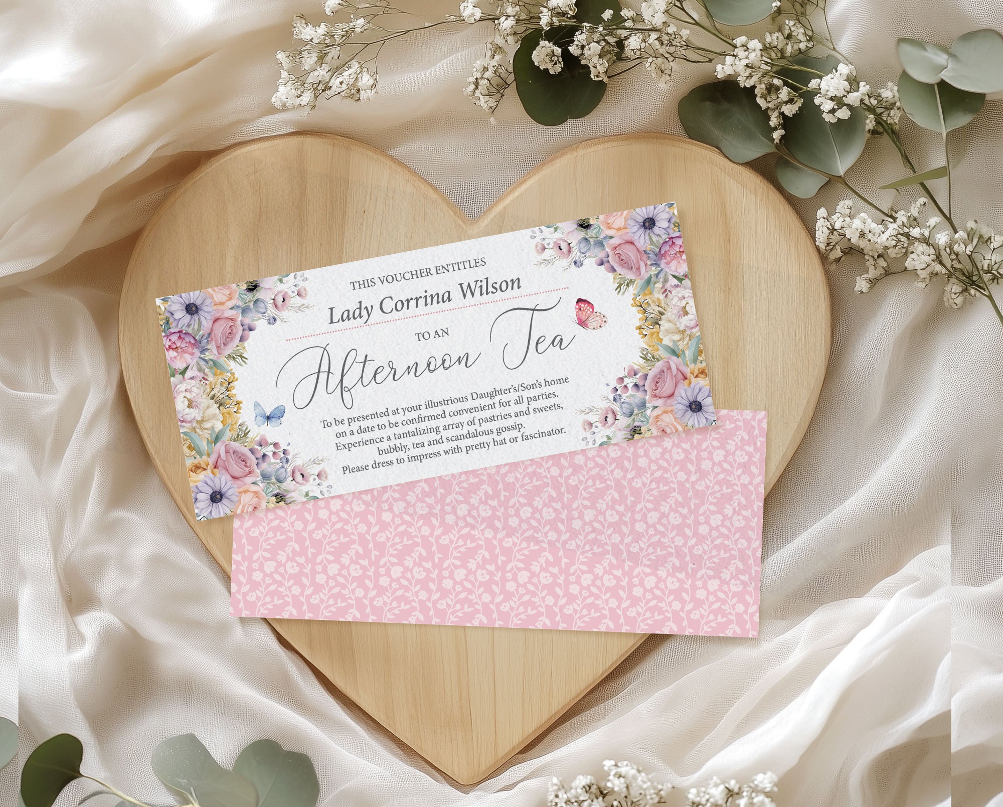 pastel Floral gift voucher on a pink envelope with a wooden heart and flowers in the background