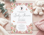 a blush pink flower baby shower tea invitation with cameo and teapot, laying on a wooden background next to a white teddy bear, some baby blankets and eucalyptus