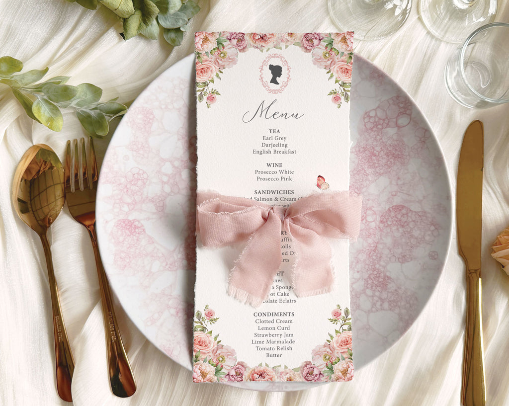 blush pink flower regency style menu card on a table setting with cutlery and plates wrapped with a pink ribbon.