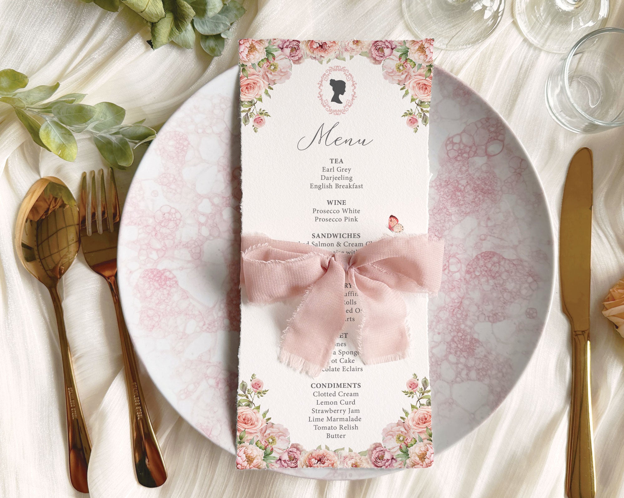 blush pink flower regency style menu card on a table setting with cutlery and plates wrapped with a pink ribbon.