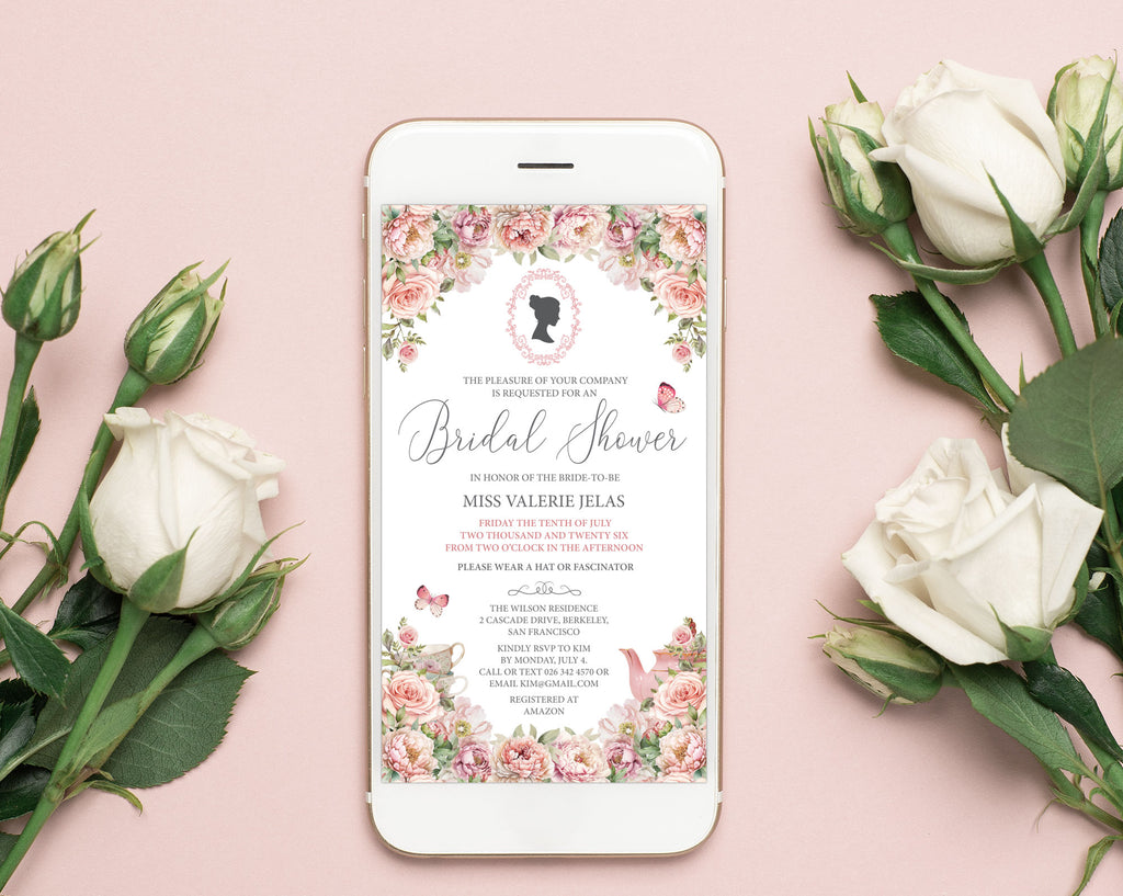 a pretty blush pink flower invitation showing on the screen of a white mobile phone laying on a pink background with white roses next to it
