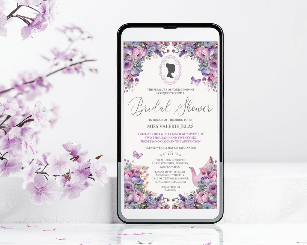 A smartphone centered on a white surface, displaying a floral bridal shower invitation design with purple and pink blossoms and black text. The phone is framed against a white background with decorative purple flowers and leaves along the left side.