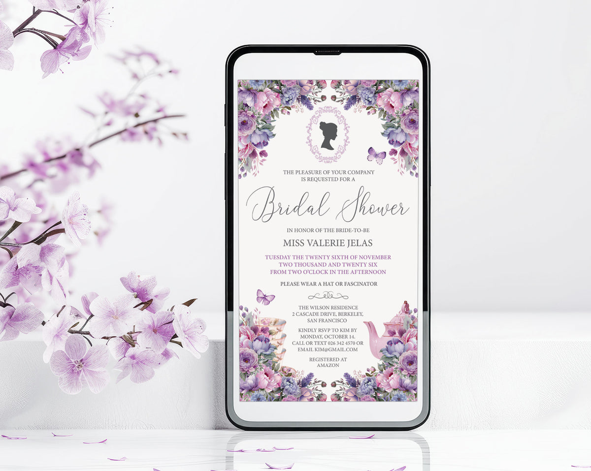 A smartphone centered on a white surface, displaying a floral bridal shower invitation design with purple and pink blossoms and black text. The phone is framed against a white background with decorative purple flowers and leaves along the left side.