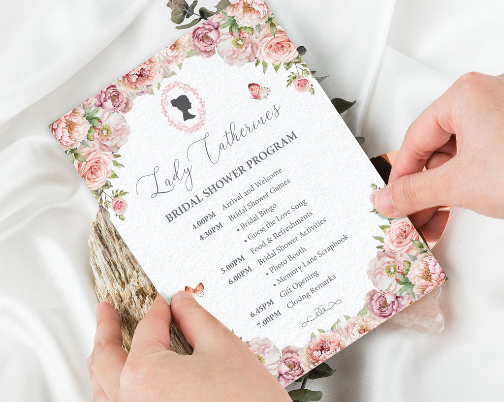 Pink Bridal shower program with floral design held by hands on a white fabric background