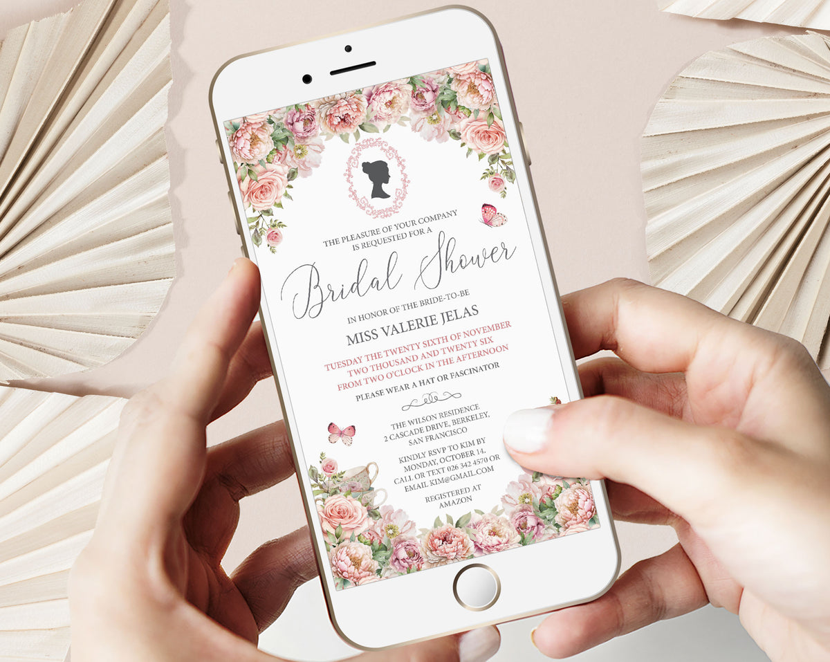 Phone displaying an afternoon tea invitation with blush pink floral design, cameo and teapot held by hands on a light background