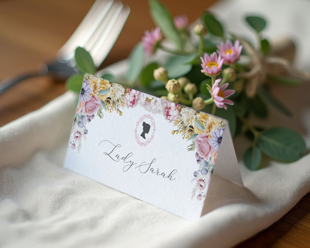 Floral place card with Victorian cameo on a table setting with flowers and a fork.