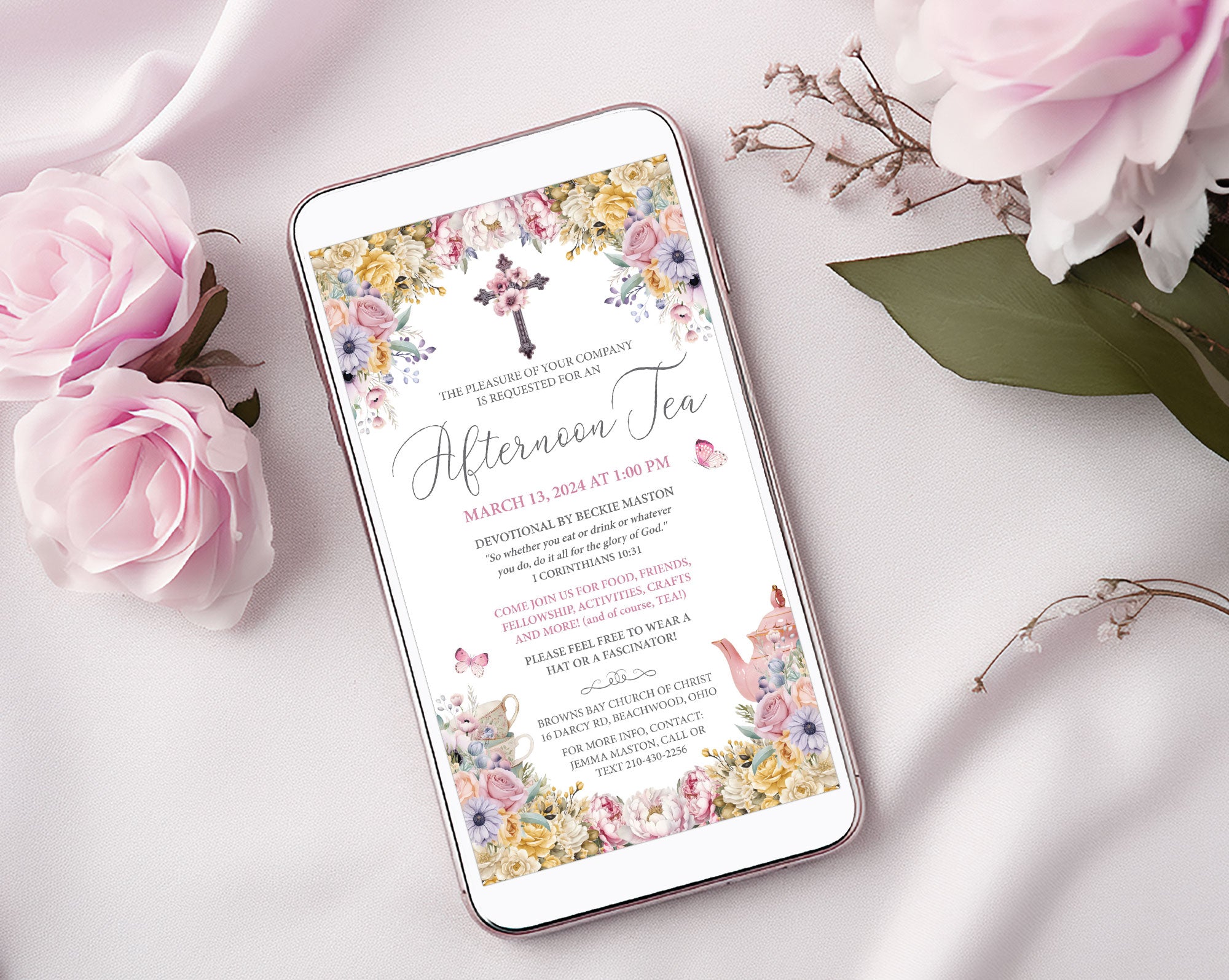 Phone displaying a church ladies afternoon tea invitation with floral design on a white surface with pink roses.