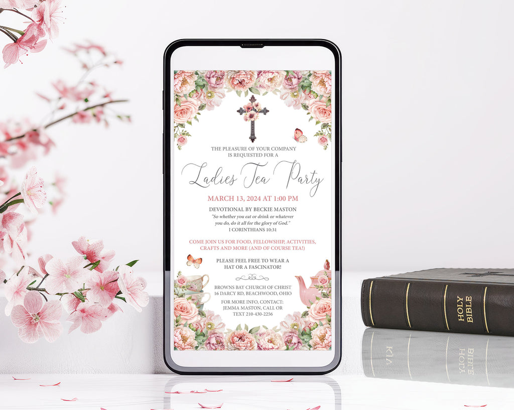 blush pink flower church event afternoon tea invitation with cross, teapot and butterflies leaning up agains a white wall next to pink blossoms and bible