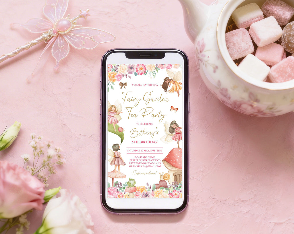 black mobile phone showing a fairy tea invitation laying on a pink background, next to a teapot full of sweets, a fairy wand and some roses