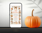A smartphone displays a fall-themed birthday invitation design with illustrations of pumpkins, leaves, and autumn motifs with a faux textured background. A real orange pumpkin sits beside the phone on a dark surface against a light draped background.