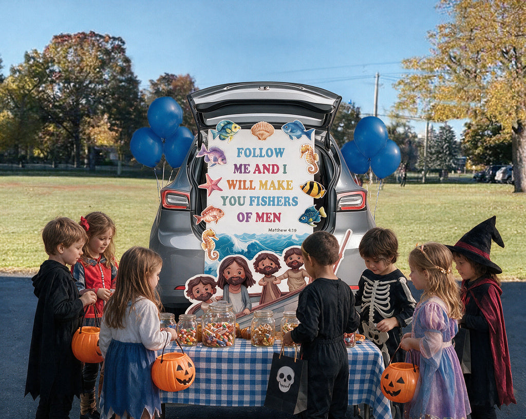 A group of children in Halloween costumes stand around a table set up in front of an open trunk of a gray car outdoors. The trunk is decorated with blue balloons and a large colorful sign reading 'FOLLOW ME AND I WILL MAKE YOU FISHERS OF MEN' with sea-themed illustrations.