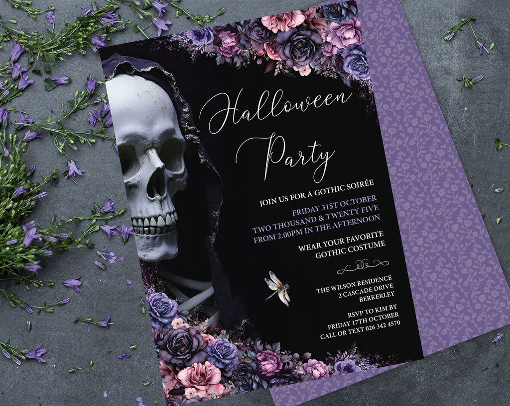 A gothic-themed Halloween party invitation card with a black background, white script text, a large white skull illustration, and purple floral borders, styled on a gray surface with scattered purple flowers and greenery.