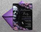 A gothic Halloween party invitation card with a black background, white script text, a large skull illustration, and purple floral accents, shown with a matching purple envelope on a gray textured fabric background.