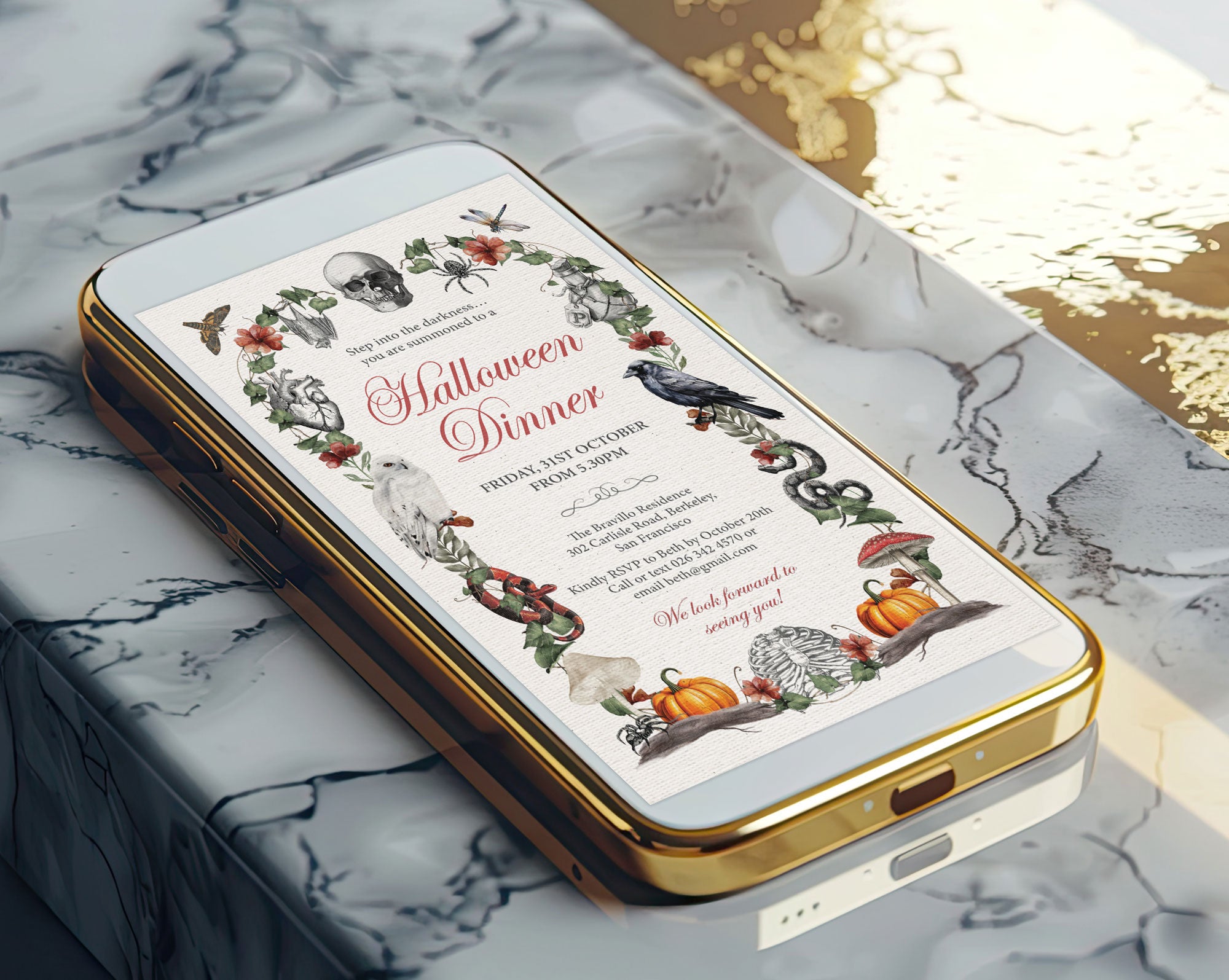 A gold-framed smartphone lying on a white and gray marble surface, displaying a Halloween dinner invitation design with illustrated pumpkins, a crow, a skull, and floral wreaths.