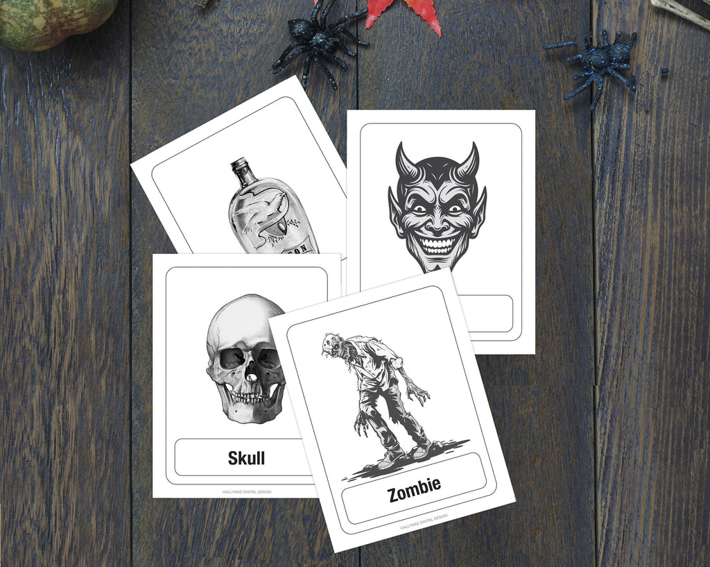 Four Halloween-themed flashcards with black and white illustrations (bottle, devil face, skull, zombie) arranged on a dark wood background with spider decorations.