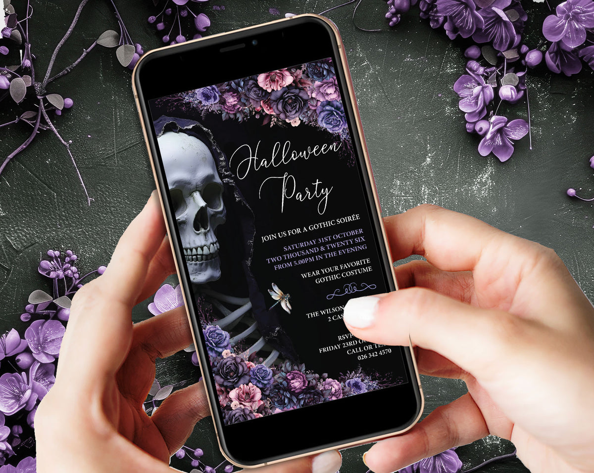 A person holds a smartphone displaying a gothic Halloween party invitation design with a skull, skeleton, and purple floral artwork. The phone is shown over a dark textured surface decorated with purple flowers.