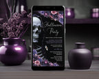 A smartphone centered on a wooden surface, displaying a Halloween party invitation with a skull, flowers, and gothic text. The scene is styled with purple vases and dried flowers in a dark indoor setting.