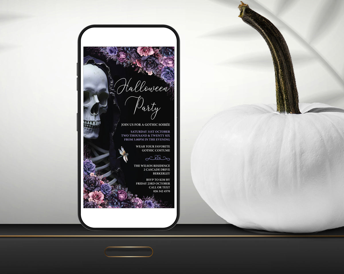 A smartphone mockup displays a Halloween party invitation design with a skull, flowers, and gothic text. The phone is styled on a dark surface next to a white decorative pumpkin against a light draped background.