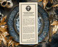 A vertical printed Halloween message card with decorative border text reading 'A Solemn Warning to Our Guests' and 'An Admission for All Hallows Eve,' styled on a dark blue patterned tray surrounded by autumn leaves, a skull, and pinecones.