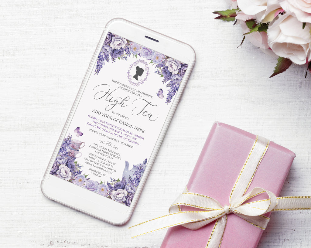 A white smartphone displaying a purple wisteria invitation design next to a pink gift box tied with a cream ribbon, styled on a white wood surface with pale pink flowers in the corner.