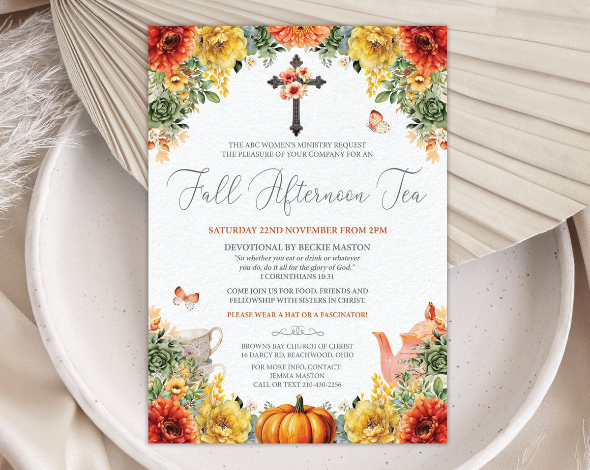 A printed fall afternoon tea invitation card styled on a white ceramic plate with a folded cream fan and dried leaves around it. The card features autumn floral borders with orange, yellow, and red flowers, green leaves, a black cross, and fall leaves, with event text in the center.