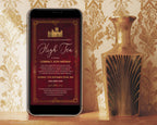 a black mobile phone with a downton birthday invitation showing on the screen leaning up again a gold patterned wall next to an art deco gold vase