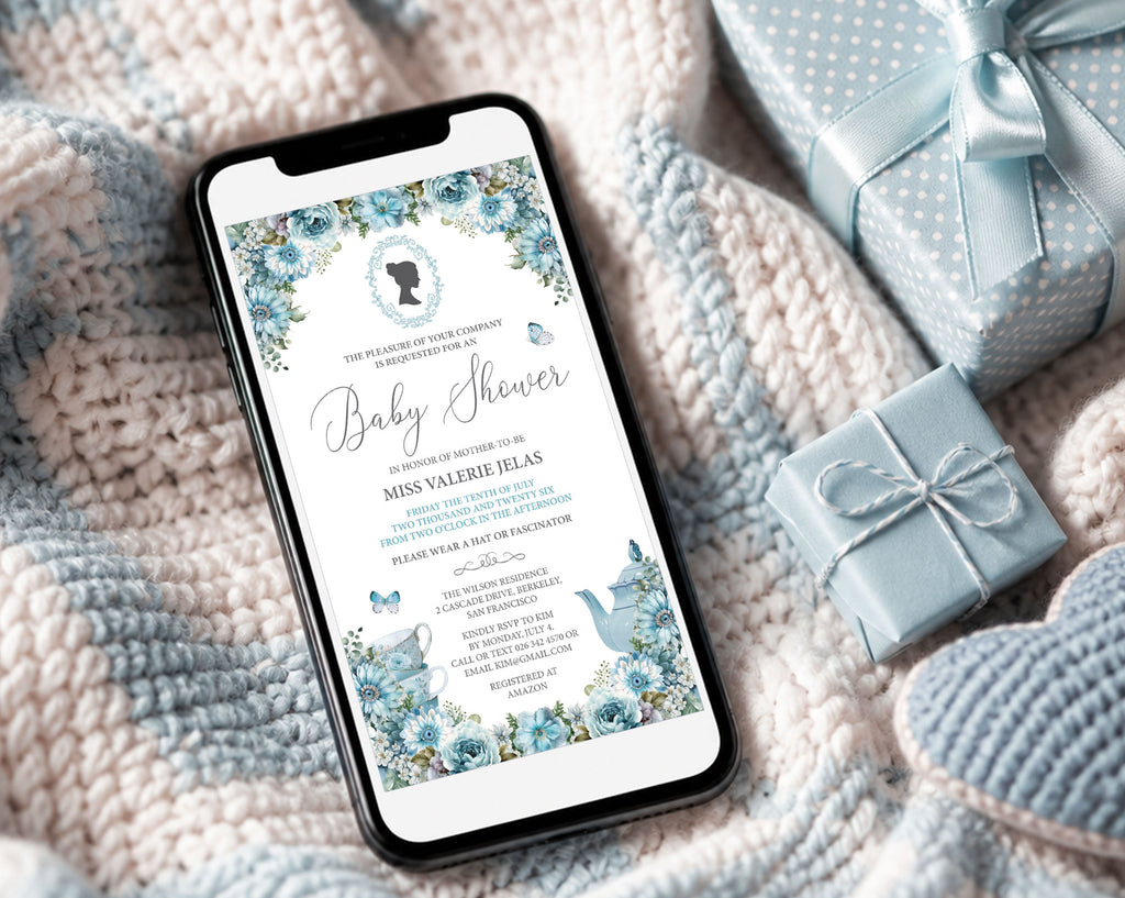 pretty blue regency style baby shower invitation showing on the screen of a mobile phone, laying on a baby blanket next to some blue wrapped gifts