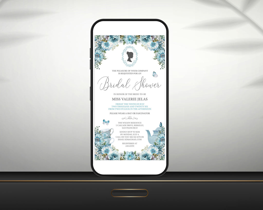 a black smart phone with a dusty blue regency style bridal shower tea invitation showing on the screen, leaning up against a white wall sitting on a black shelf