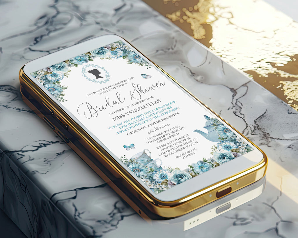 A gold mobile phone showing a pretty dusty blue bridal shower victorian style invitation on the screen laying on a marble surface