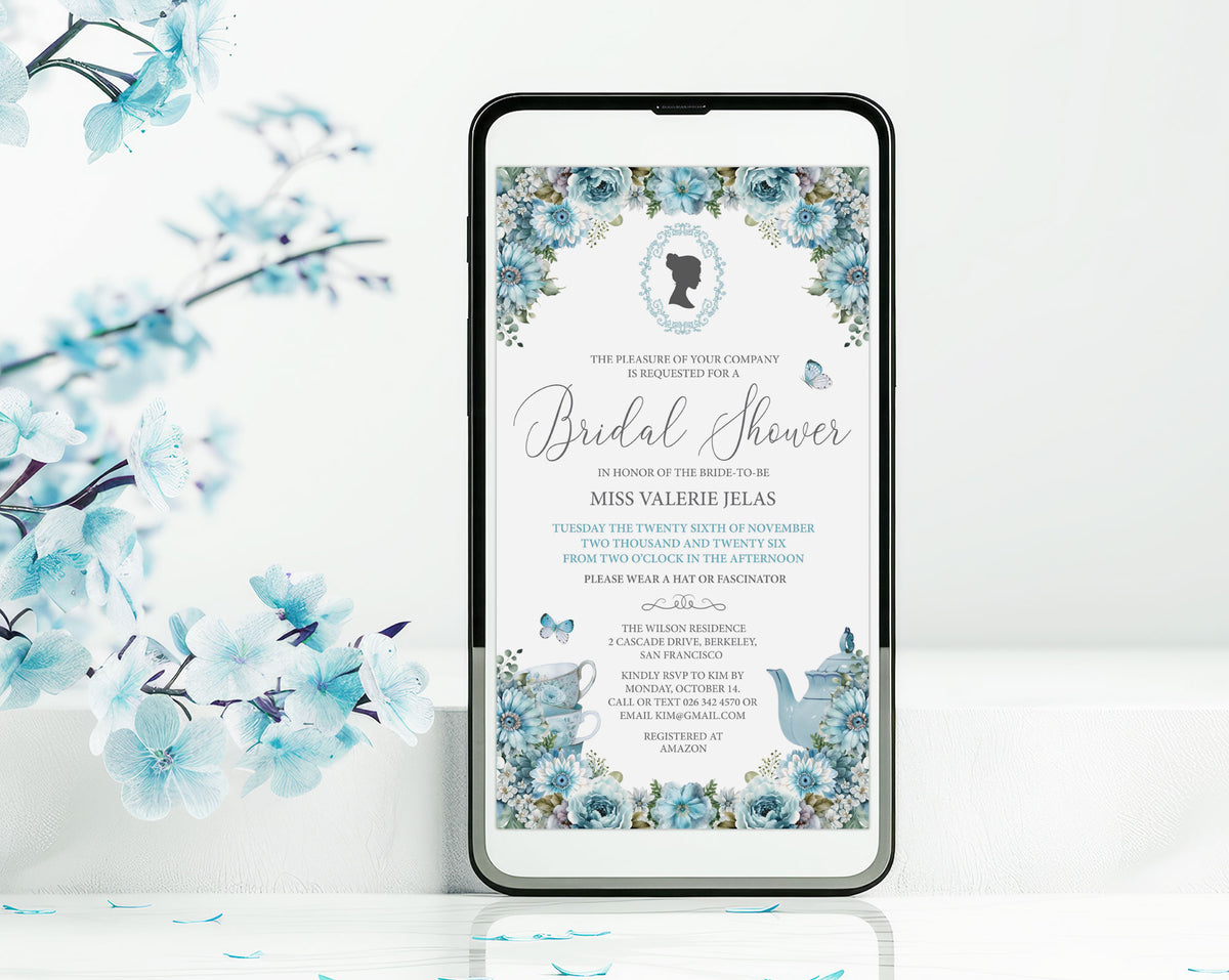 A smartphone mockup displays a dusty blue flower regency style bridal shower invitation. The phone is shown standing upright on a white surface with decorative blue blossoms in the background.