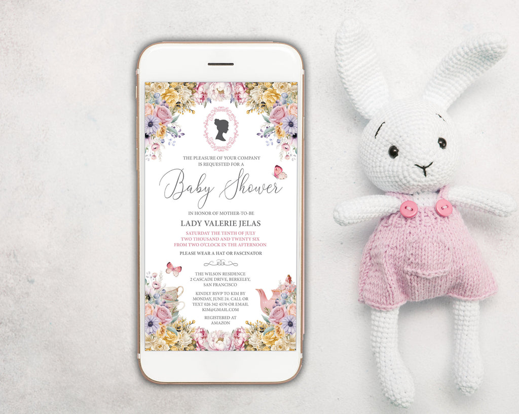 a pastel baby shower invitation showing on the screen of a white mobile phone, laying on a white background next to a stuffed rabbit with pink dungarees