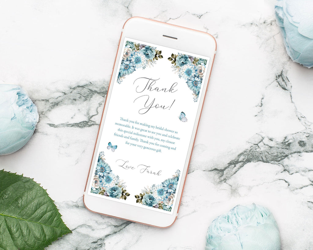 elegant dusty blue thank you note displayed on a mobile phone laying on a marble background with blue peonies