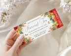 A hand holds a printed event ticket for 'Urban Farm Presents Harvest Tea' against a soft cream fabric background with blurred white flowers.