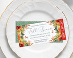 A printed event ticket for an 'Urban Farm Presents Fall Dinner' displayed on a white ceramic plate with gold trim, with another white plate behind it.