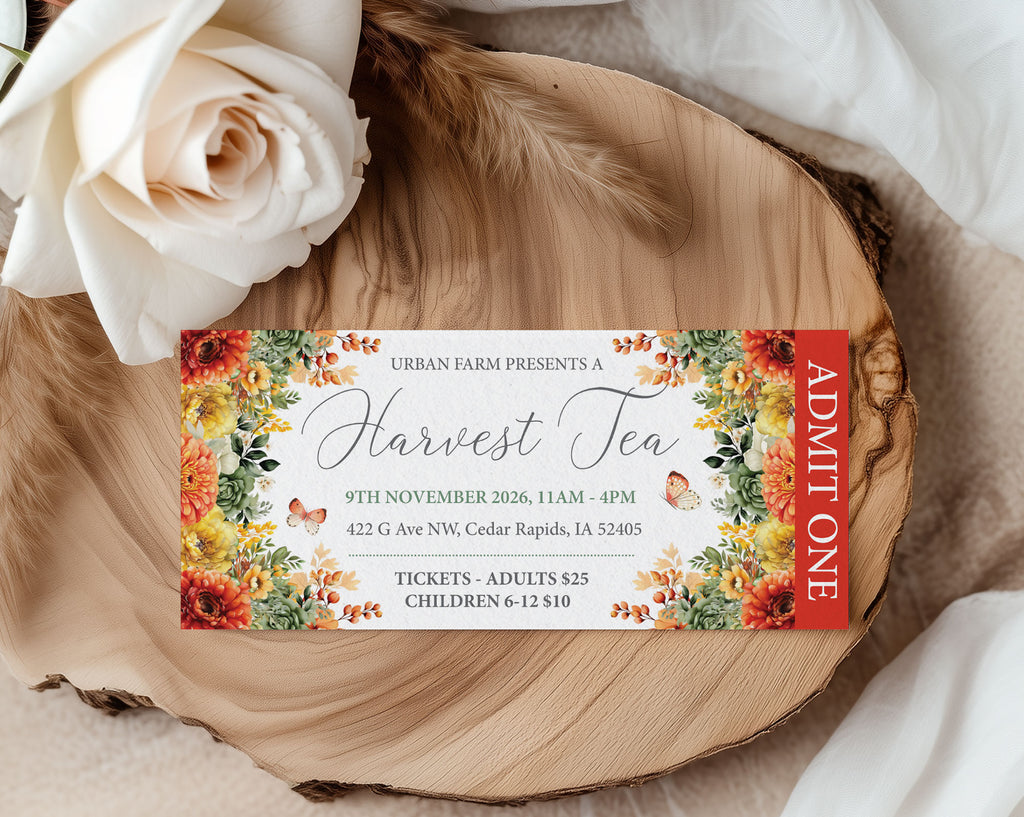 A printed event ticket for 'Urban Farm Presents a Harvest Tea' styled on a rustic wood slice with a white rose and draped fabric in the background. The ticket features a white center with elegant script text, surrounded by a colorful floral border in orange, yellow, and green, with a red vertical 'ADMIT ONE' stripe on the right.