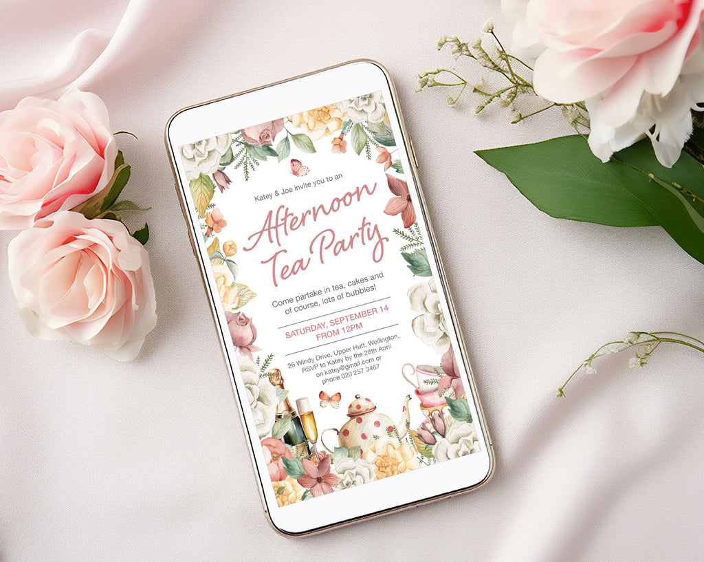 a mobile showing an afternoon tea party invitation with champagne and teapot graphics laying on a silk background next to some pink flowers