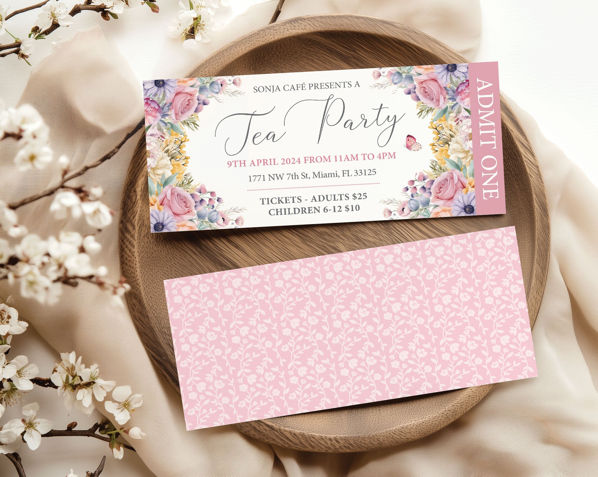 pastel Tea party event ticket with floral design on a wooden plate with flowers.