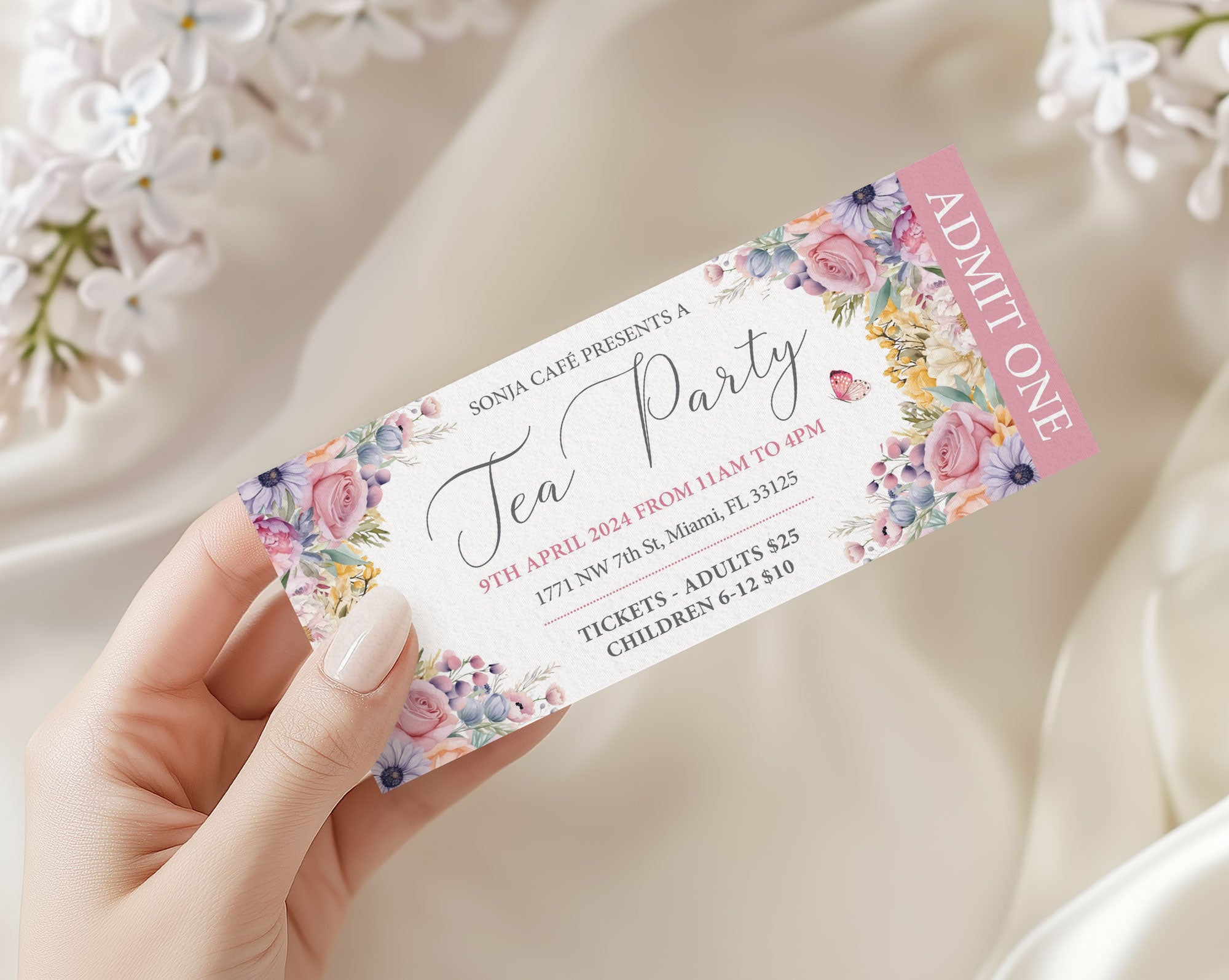 pastel flower Tea party ticket with floral design held by a ladies hand, surrounded by white flowers.