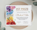 A printed certificate for 1st Prize Rainbow Tea Table Decoration styled on a woven round mat with eucalyptus leaves. The certificate features colorful watercolor flowers on the left side and elegant gold text on a white background.