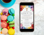 a black mobile phone showing a church rainbow tea invitation, laying on a marble surface next to a tray fill of colorful macarons and a blue tea cup