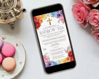 a bright rainbow tea mobile showing on the screen of a black mobile phone laying on a grey table with a silver teapot, some pink roses and macarons on a plate