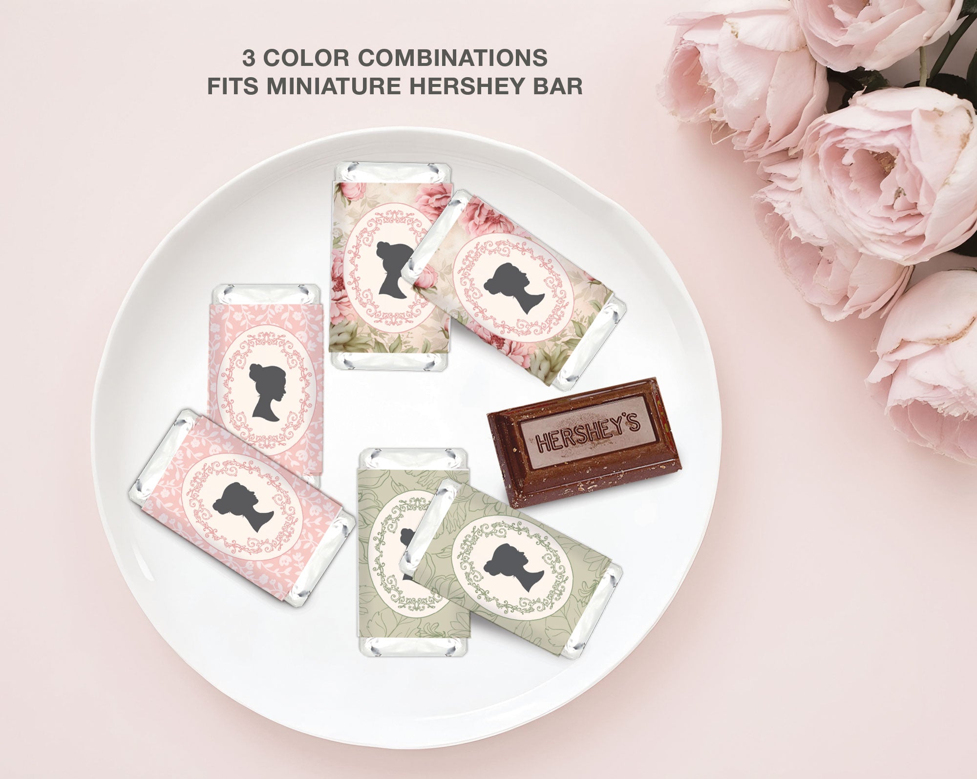 Miniature Hershey bars with decorative bridgerton inspired wrappers on a white plate, surrounded by pink roses