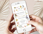 two hands holding a mobile phone with a bird and wildflower baby shower invitation showing on the screen