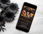 A smartphone lying on a white wood surface, displaying a Halloween invitation design with witch illustrations and gold script text. Black artificial flowers are arranged around it on the left.