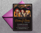 A Halloween-themed cocktail night invitation card with a black frame, featuring an illustration of three women in witch hats and gold script text, displayed in front of a bright pink envelope on a gray textured background.