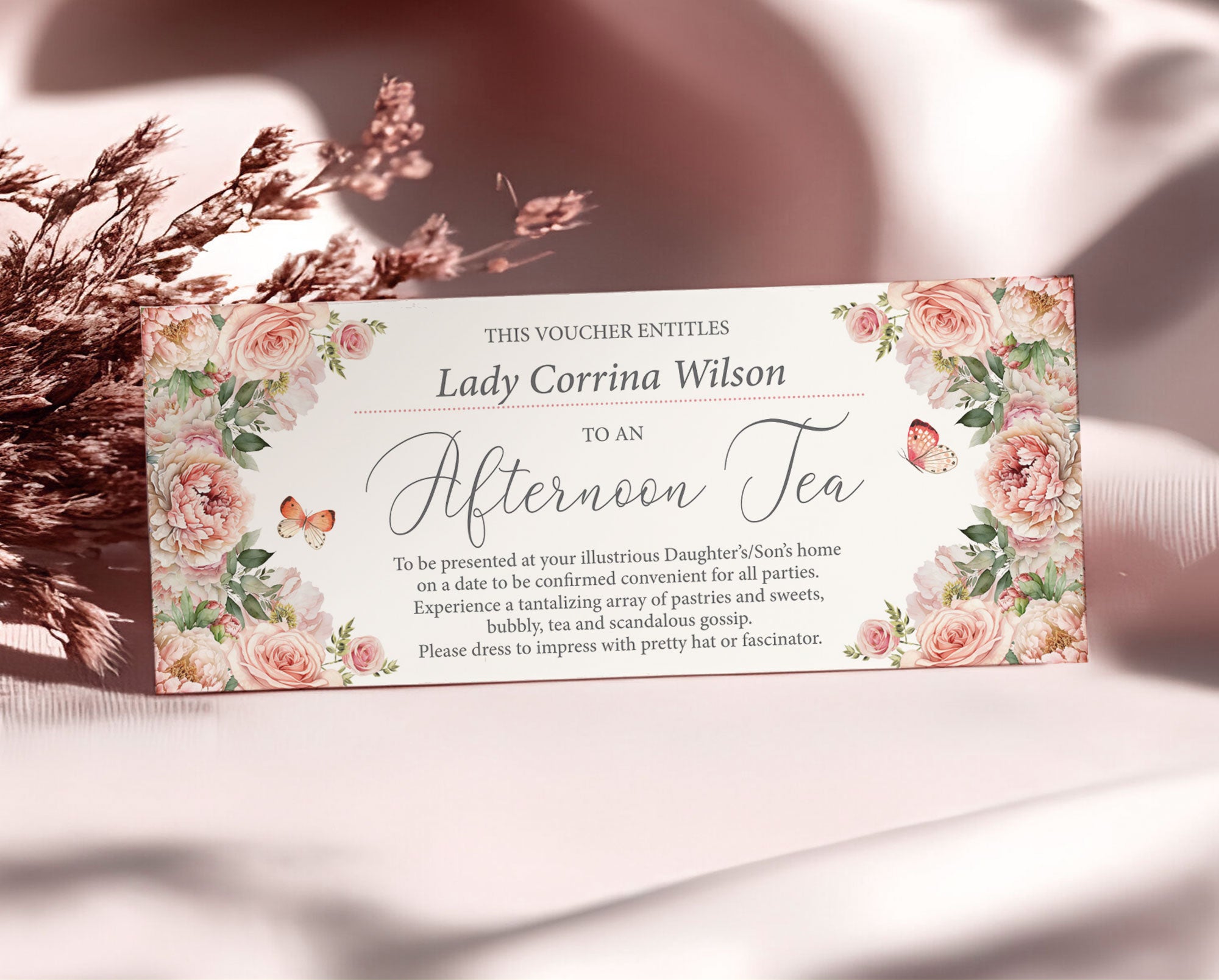 elegant blush pink flower voucher that offers a home made afternoon tea leaning up against some dried flowers and a silk pink background
