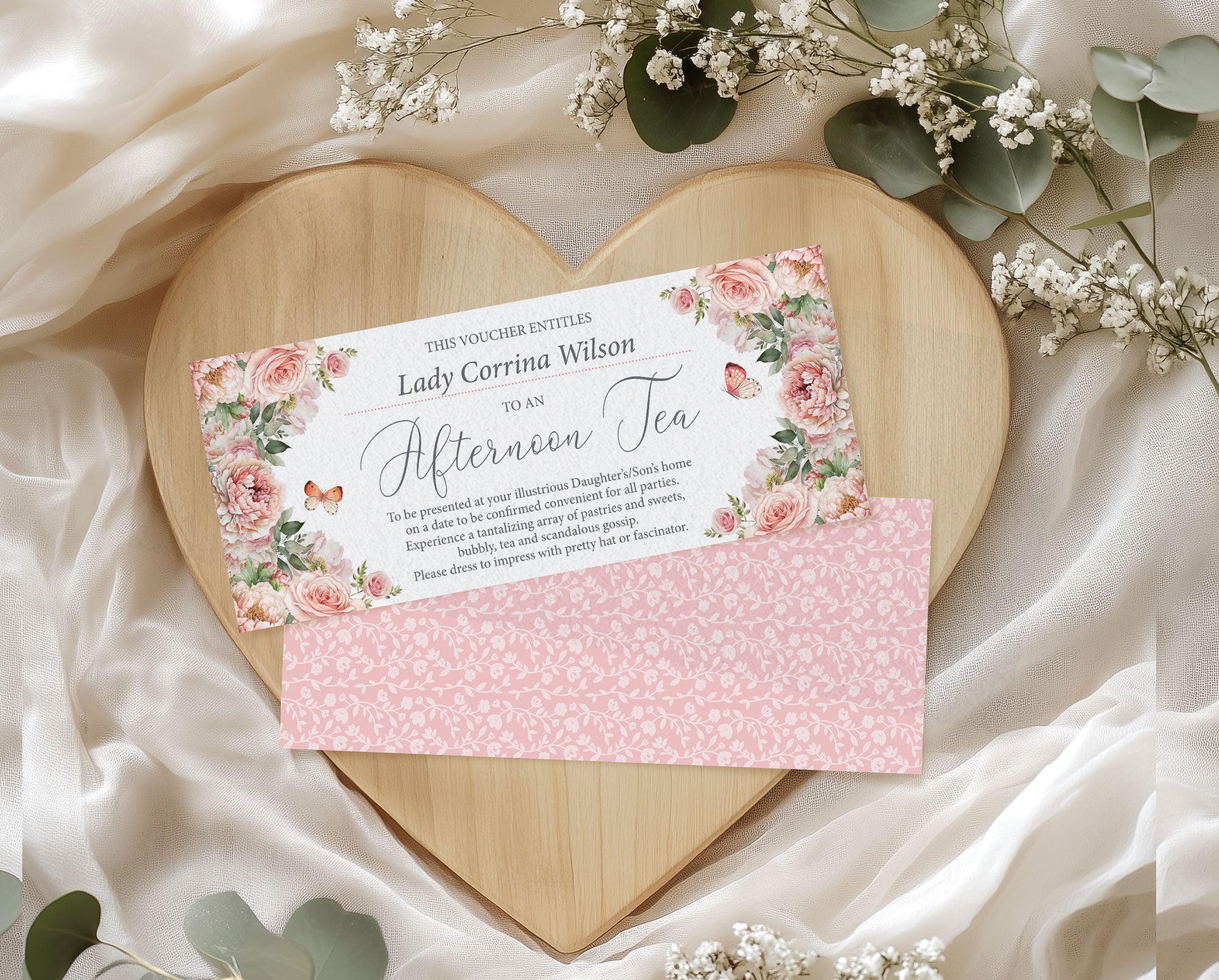 Gift voucher with floral design on a heart-shaped wooden board surrounded by flowers.