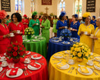a church filled with bright colored tables for a Rainbow tea, with people in co-ordinating colors milling around with cups of tea talking to each other